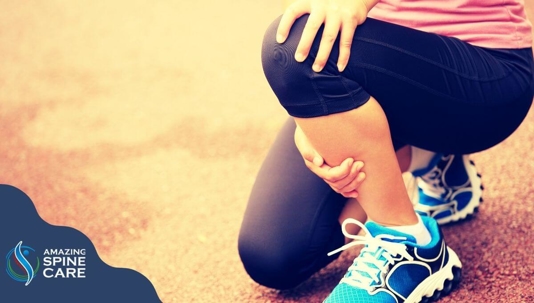 Woman in workout clothes clutching her knee