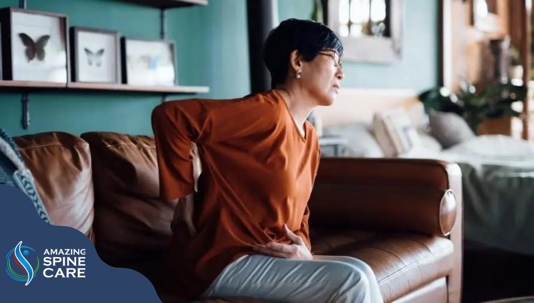 woman on couch leans forward in pain