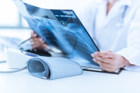 Woman Doctor Looking at X-Ray Radiography in patient's Room